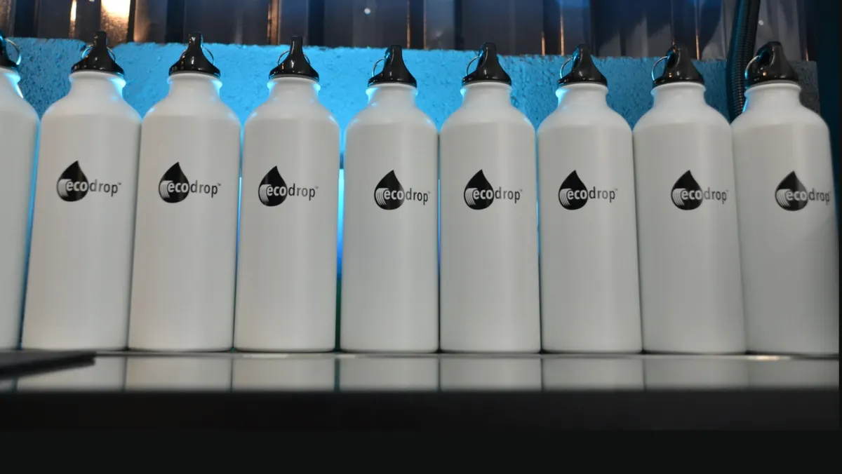 A row of white Ecodrop bottles lined up at a refill station